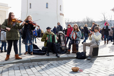 VILNIUS, LITHUANIA -MARCH 04, 2017: Young Lithuanian street musicians play and sing the folk country songs to earn a little money for foodのeditorial素材