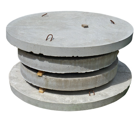Stack of new industrial round concrete  hatches for the sewerage system. Isolated on white