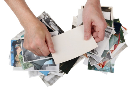 Nostalgia by youth  concept.  An elderly man looks through old shabby family photos. Isolated on white top view studio shotの写真素材