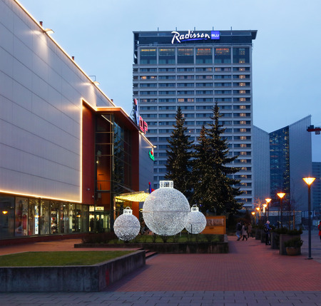  VILNIUS, LITHUANIA - DECEMBER 30, 2017: Christmas light balls and fir trees decorate the park near the Central Shop and the Radisson Blue Hotel in Lithuanian capitalのeditorial素材