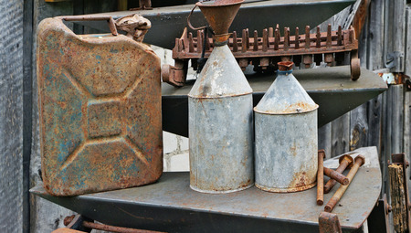 Old rusty vintage metal cans for kerosene and gasoline near the village barnの写真素材