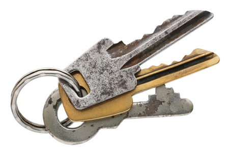 Three old rusty vintage keys connected by a metal ring. Isolated on white studio macro shot