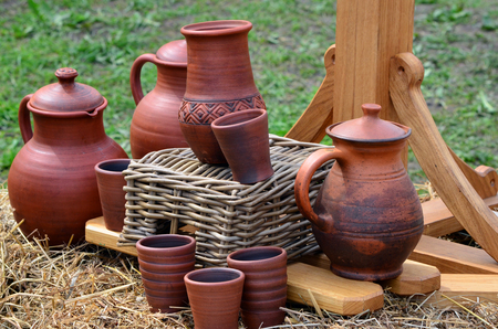 Handmade clay jugs and mugs are sold at the village fair under the open skyの写真素材