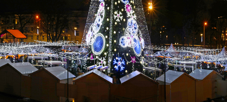 VILNIUS, LITHUANIA - DECEMBER 26, 2018: Christmas European  city square with  souvenir shops and decorated illuminate fir tree on  European old town. People celebrate Xmas  holidaysのeditorial素材