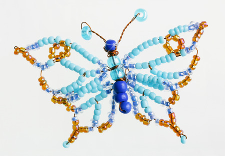 Homemade butterfly made of beads and wire macro on whiteの写真素材