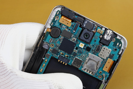 A technician repair printed circuit board for  for used  wireless mobile phone. Modern technology  macro concept.の写真素材