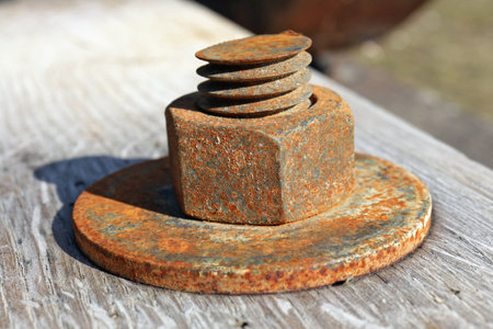 Large rusty nut holds wood aged planks together background. Central focus on nut as the main objectの写真素材
