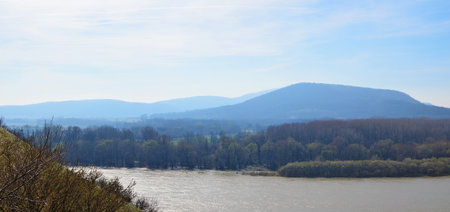 Panoramic March European landscape with river and mountais. Sunny day shotの写真素材