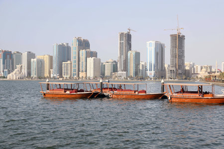 Dubai, United Arab Emirates - December 03, 2019. The reverse side of the capital seaport. A small wooden and steel private no name merchant ships and boats  against the background of urban skyscrapersの写真素材