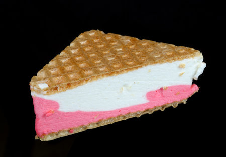 Cake made of triangular waffles and creamy pink ice cream. Isolated on black night food macroの写真素材