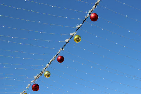 Multi-colored glass balls and LED garlands adorn the sunny blue sky of Christmas    Israelの写真素材