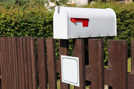 White metal mailbox mounted on a rustic  fenceの写真素材