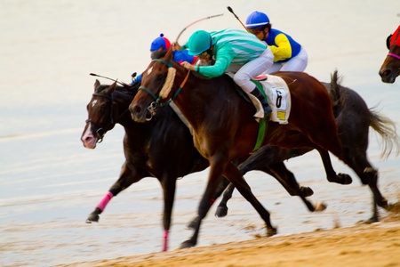 SANLUCAR DE BARRAMEDA, CADIZ, SPAIN - AUGUST 11: Unidentified riders race horses on Sanlucar de Barrameda beach on August 11, 2011 in Sanlucar de Barrameda, Cadiz, Spain.