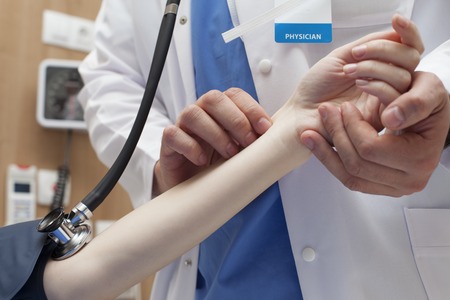 Doctor measuring pulse patient