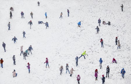 A field during winter, full of playing with the snow children, blurred faces. の写真素材