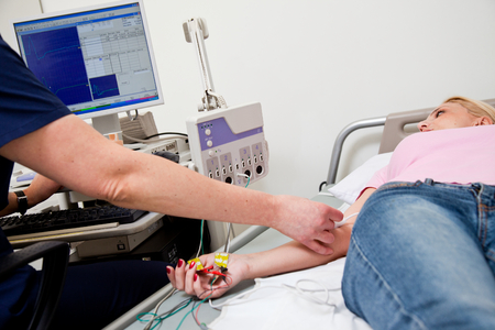 Woman being examed on hospital bed with electromyography systemの写真素材
