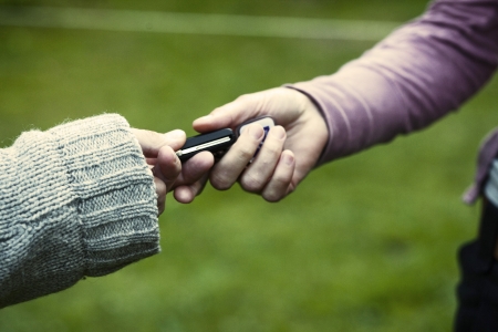 One hand pasing a key to anotherの写真素材