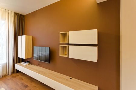 Wall in living room with cupboard and TV set