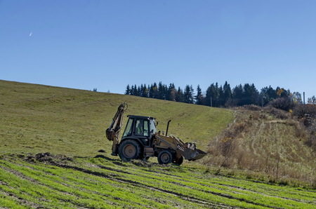 Wheeled tractor with crane and scoop  go for a worg, Plana mountain, Bulgaria