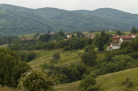 Scene with mountain glade, forest and residential district of bulgarian village Plana, Plana...