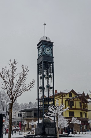 Facade of the snowy town  clock tower in winter, Bankya town, Sofia, Bulgariaの写真素材