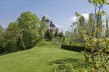 Early springtime green, bell tower and church with modern architecture in district Drujba, Sofia,...