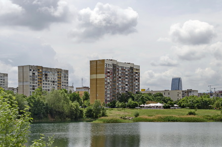 Spring panorama of a part of residential district neighborhood along a lake with green trees, shrubs and flowers, Drujba, Sofia, Bulgariaの写真素材