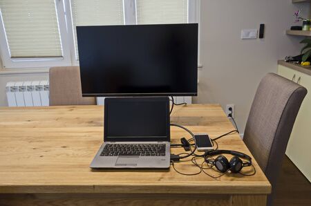 Part of a work table with a laptop, monitor, mobile telephone and headset in a recently renovated...