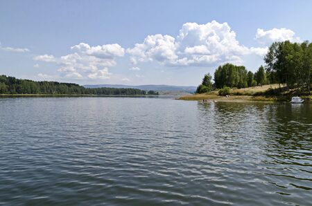 General view of the artificial Vlasina mountain lake surrounded by a pine tree forest in summer, Southeastern Serbia, Europeの写真素材