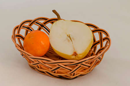 Fresh ripe orange and a piece of yellow pear in a basket, ready to eat, Sofia, Bulgariaの写真素材