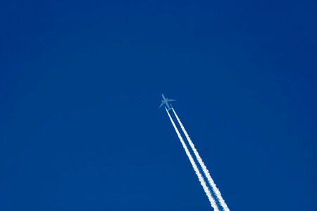 Jet plane in the blue sky with white tracks over the village of Nisovo, Bulgaria