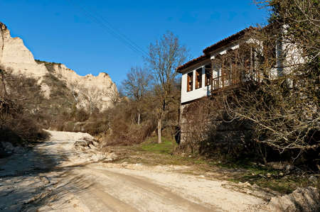 Old traditional houses against the backdrop of the famous sand pyramids in the town of Melnik, Bulgariaの写真素材