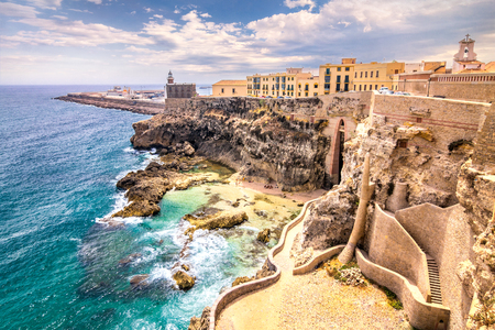 City walls, lighthouse and harbor in Melilla, Spanish province in Morocco. The rocky coast of the Mediterranean Sea.の写真素材