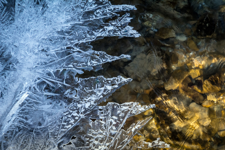 Ice texture on a frozen stream in winter.の写真素材