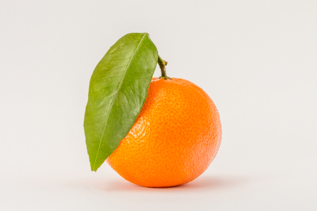 Ripe mandarin orange citrus with green leaf isolated on white backgroundの写真素材
