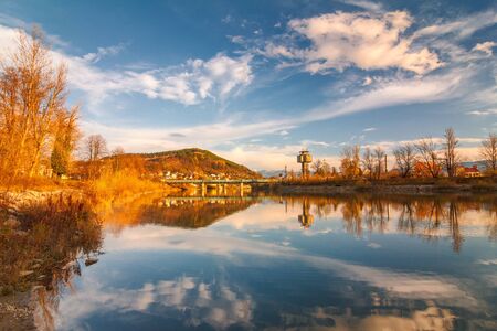 Mirroring autumn landscape in The Vah river near The Zilina town, Slovakia, Europe.