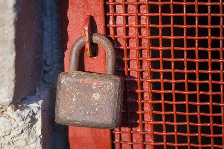Old rusty padlock on an iron door.の写真素材