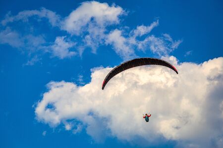 Flying paraglider on a background of blue sky with clouds.の写真素材