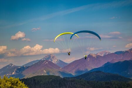Flying paragliders from the Stranik hill over the mountainous landscape of the Zilina basin in the north of Slovakia.
Mala Fatra National Park in the background, Slovakia, Europe.の写真素材
