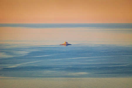 A lonely small island with a church in the middle of the Adriatic Sea at the colorful dawn of the day, Croatia, Europe.の写真素材
