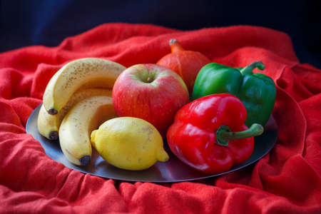 Still life of vegetables and fruits of various kinds on a plate on an arranged background.の写真素材