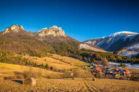 Rural landscape with mountain peaks on background in early spring. The Stefanova village in Vratna valley of The Mala Fatra national park, Slovakia, Europe.の写真素材