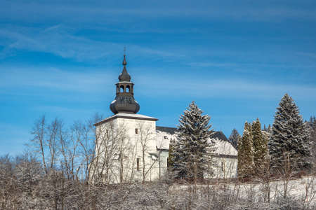 View of church in snowy winter landscape. Lietava village in northwest of Slovakia, Europe.の写真素材