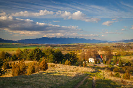 Sunny spring rural landscape, church in the valley with mountains at the background. Turiec Valley in Slovakia, Europe.の写真素材