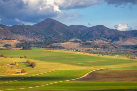 Sunny spring rural landscape, valley of fields and meadows with mountains in the background. Turiec Valley in Slovakia, Europe.の写真素材