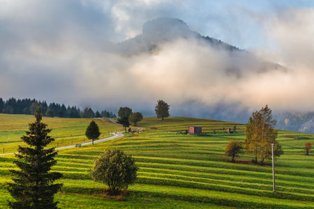 Autumn misty mountainous landscape with morning sun light shining through the clouds. The Orava region of Slovakia, Europe.の写真素材