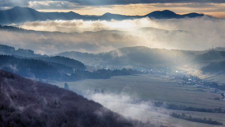 Mountainous landscape with misty valleys at dramatic light in sunset. Northwestern Slovakia, Europe.の写真素材