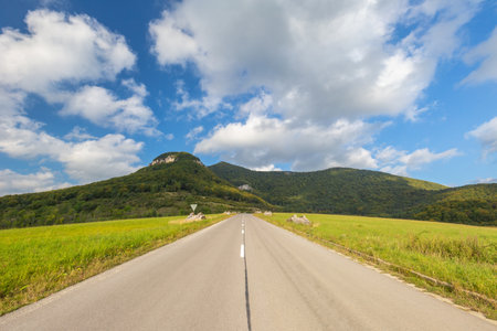 Summer landscape with a road going up to the hills.の写真素材