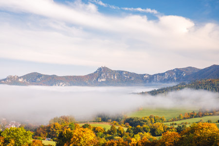 A landscape with mountains surrounded by fog in the autumn season. The Sulov Rocks, national nature reserve in northwest of Slovakia, Europe.の写真素材