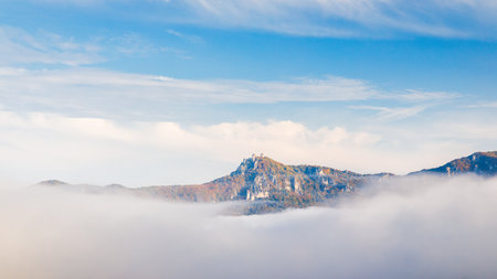 A mountain surrounded by fog in the autumn season. The Sulov Rocks, national nature reserve in northwest of Slovakia, Europe.の写真素材